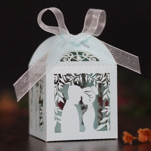 Macro detail of laser-cut light blue wedding candy box with couple silhouette