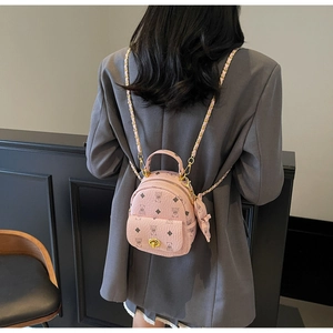 Detail eines rosa Mini-Rucksacks mit Bärenmuster und Goldkette am Modell