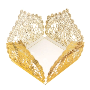 Detail of laser-cut gold lace hollow flower pattern on a decorative wedding candy box