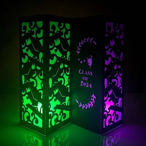 Macro detail of Class of 2024 paper lantern with cutout silhouettes and glowing LED light