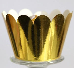 Macro detail of metallic gold cupcake wrappers with elegant scalloped wavy edges decoration