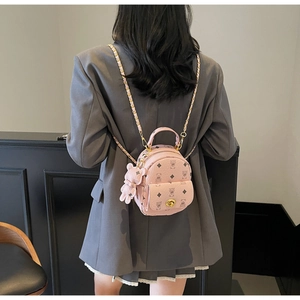 Detailaufnahme eines rosa Mini-Rucksacks mit Bärenmuster und Kettenriemen am Modell