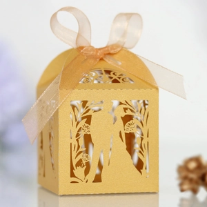 Detailed laser-cut wedding favor box in gold with ribbon and bride and groom silhouette