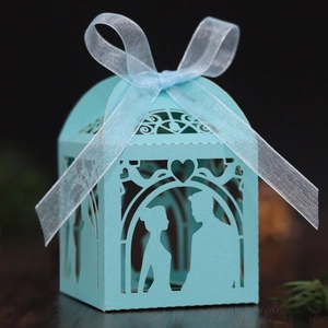 Detailed laser-cut light blue wedding candy box with couple silhouette and white ribbon bow