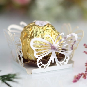 Macro detail of laser-cut butterfly candy box with silver edges for wedding favors