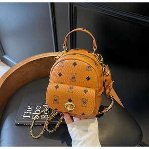 Detail des karamellfarbenen Mini-Rucksacks mit Kieselleder, Monogramm und Kettenriemen