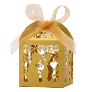 Close-up of golden laser-cut wedding favor box with bride and groom silhouette