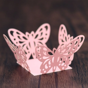 Macro shot of laser-cut pink butterfly hollow decorations for wedding and party favor boxes