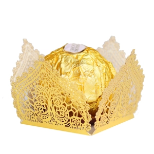 Macro detail of laser-cut gold lace favor box with intricate vine pattern for weddings