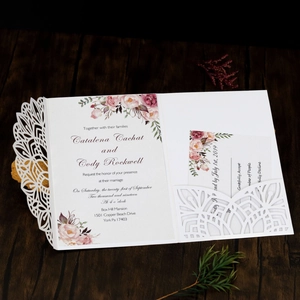 Detailed laser cut lace wedding invitation with floral insert and RSVP card on wood