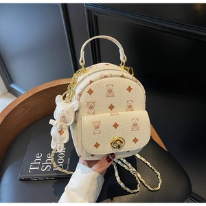 Nahaufnahme des cremefarbenen Mini-Rucksacks mit Bärenmuster und goldenem Drehverschluss