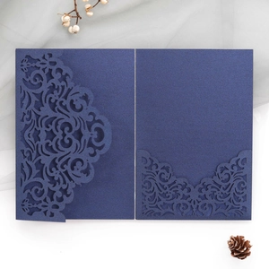 Detail of navy blue laser cut wedding invitation with intricate European floral pattern