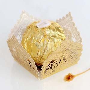 Detail of laser-cut gold lace candy box with floral patterns for wedding party favor
