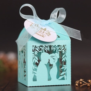 Détail d'une boîte cadeau bleu clair découpée au laser avec motif et ruban soyeux