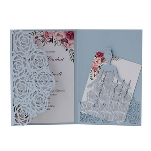 Close-up of laser-cut light blue rose patterns on elegant wedding invitation cards