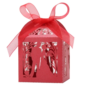 Detail of red laser-cut wedding favor box with ribbon and bride and groom silhouette