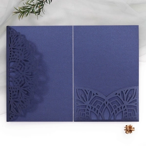 Navy blue laser-cut floral invitation cover with pearlescent finish on white background