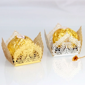 Detail of laser-cut gold and white chocolate wrappers with intricate floral patterns