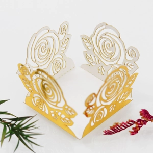 Détail boîte cadeau découpée au laser avec motif de rose blanc et doré pour mariages