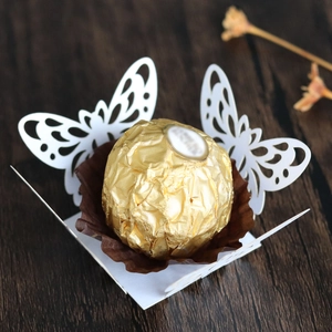 Detail of white laser-cut butterfly candy box with intricate lace patterns for weddings