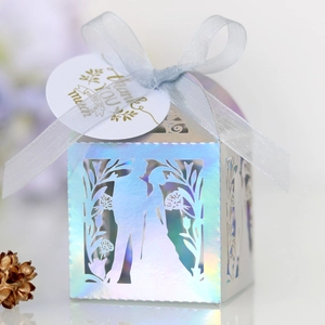 Détail d'une boîte cadeau holographique découpée au laser avec ruban et étiquette