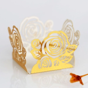 Détail de l'emballage ajouré en papier doré motif rose pour cupcakes et mariages