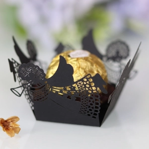 Close-up of laser-cut black angel silhouette cupcake wrapper for wedding party decor
