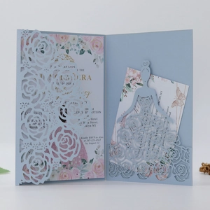 Detail of light blue laser-cut rose wedding invitation with pink floral inserts