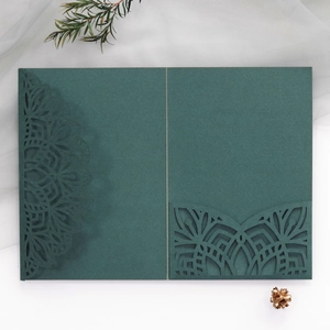 Deep green laser cut wedding invitation suite with intricate mandala pattern and pocket
