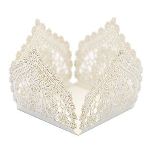 Close-up of laser-cut lace pattern on white wedding favors box with intricate details