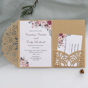Detailed view of laser-cut gold wedding invitation with floral card and RSVP insert