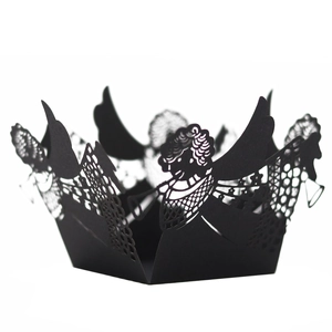 Macro detail of laser-cut black cupcake wrapper with angel and lace pattern
