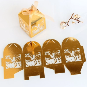 Macro view of golden pumpkin laser-cut candy box with orange ribbon and flat template