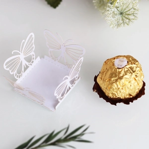 Macro view of white laser-cut butterfly hollow candy box with intricate lace details