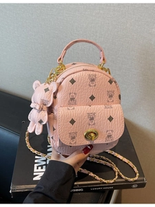Mini-Rucksack aus rosa Kunstleder mit Bärenmuster und goldener Kette in der Hand