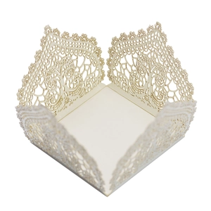 Macro detail of laser-cut lace hollow pattern on ivory paper candy gift box for wedding party