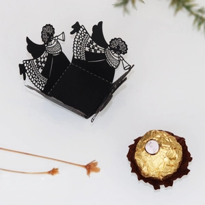 Laser cut black paper wrapper with angel silhouette for party favors and cupcakes
