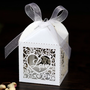 Detail of white laser-cut LOVE candy box with pearlescent paper and ribbon bow