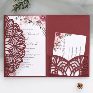 Elegant burgundy laser-cut wedding invitation set with floral inner card on white background