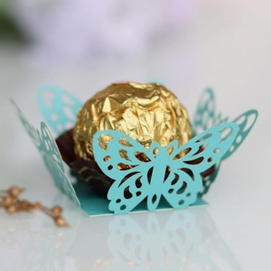 Macro shot of laser-cut butterfly cupcake wrapper in light blue for wedding treats