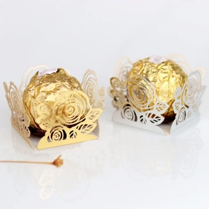 Détail du motif de rose découpé au laser sur les boîtes à bonbons dorées et nacrées