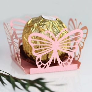 Close-up of laser-cut pink butterfly hollow candy box with elegant floral lace detail