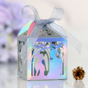 Detailed laser cut wedding candy box with iridescent finish and blue silk ribbon
