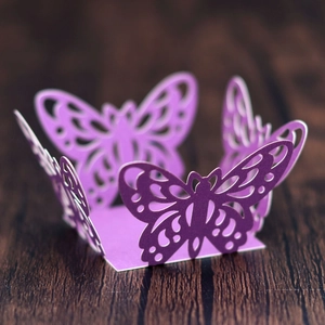 Detailed macro view of laser-cut purple cupcake wrappers with hollow butterfly design