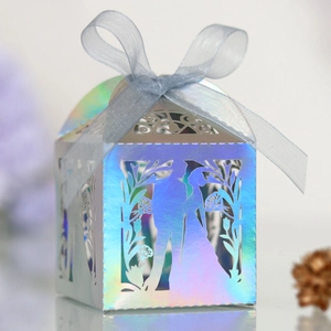 Detail of laser-cut wedding favor box with iridescent finish and blue organza ribbon