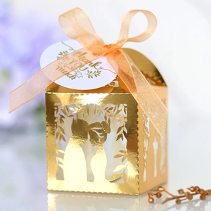 Détail boîte cadeau dorée avec silhouette de couple et élégant ruban de soie