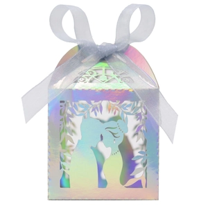 Macro view of laser-cut wedding candy box featuring a romantic silhouette and silk ribbon