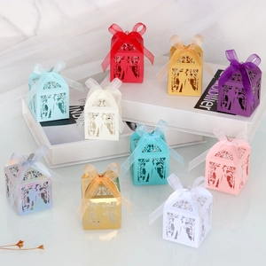 Macro detail of laser-cut wedding favors boxes with bride and groom silhouette and ribbons