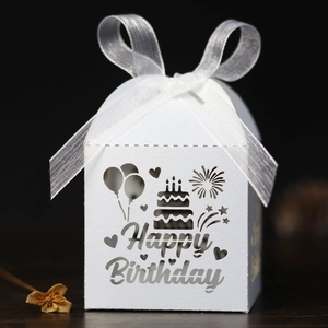 Détail boîte cadeau Happy Birthday blanche découpée au laser avec ruban et motifs festifs