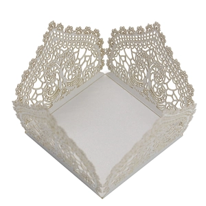 Detail of white laser-cut filigree candy box with intricate floral pattern for weddings